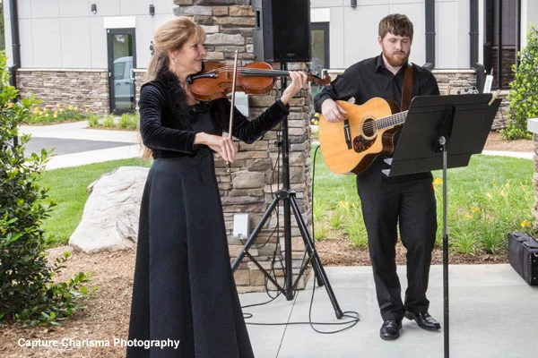 Christine playing violin with guitarist